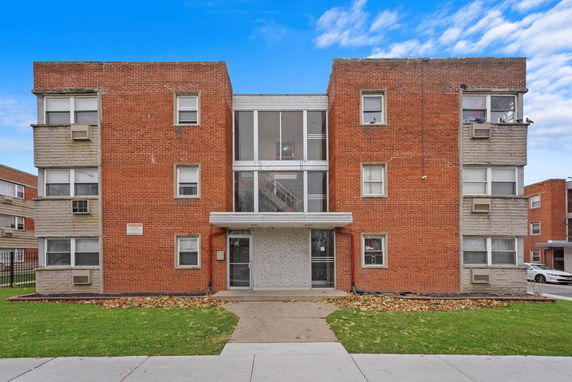 Front view of a three-story brick apartment building.
