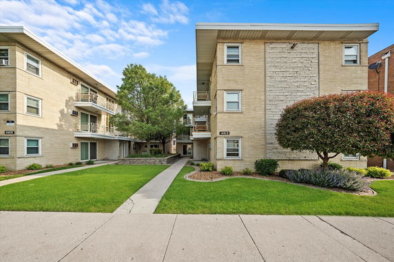 Front view of a multi-story apartment building with balconies.