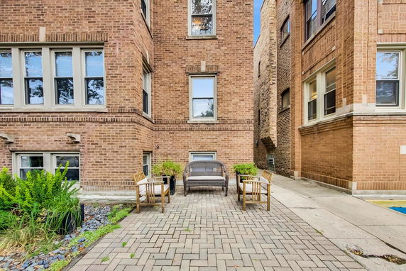 Front view of a brick building with a patio and seating area.