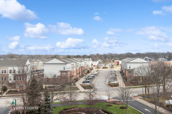 Aerial view of a suburban neighborhood with row houses and an adjacent road.