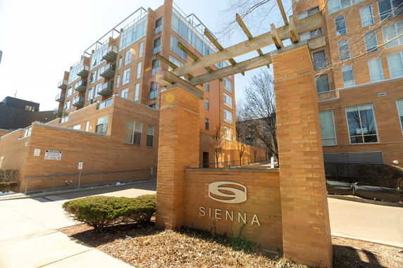 Front view of a multi-story brick apartment building with balconies.