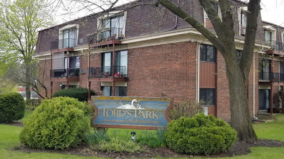 Front view of a multi-story condominium building with balconies.