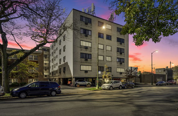 Front view of a multi-story apartment building during sunset.