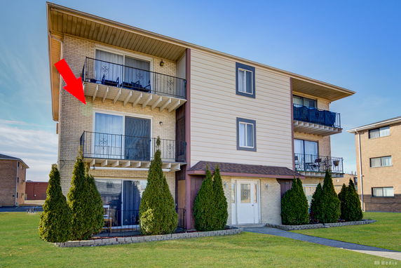 Front view of a multi-story building with balconies.