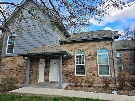 Front view of a house with a brick facade and arched windows.