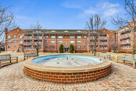 Front view of a multi-story brick building with balconies and main entrance.