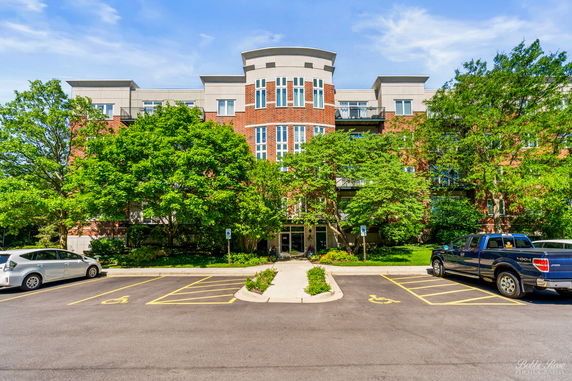 Front view of a multi-story building with red brick facade and large windows.