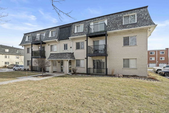 Front view of a multi-story apartment building with balconies.