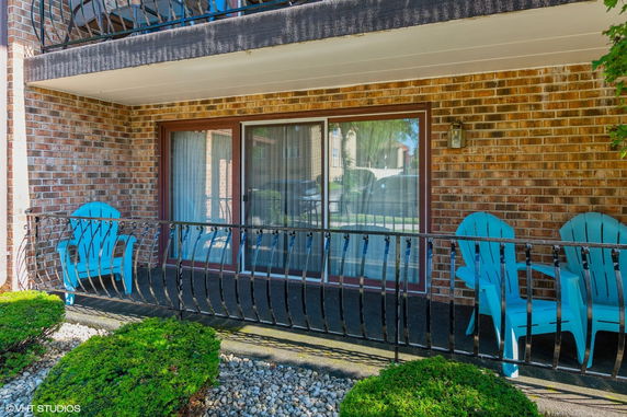 Front view of a building with a patio and sliding glass doors.