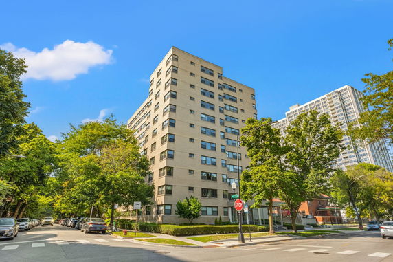 Front view of a multi-story apartment building on a street corner.