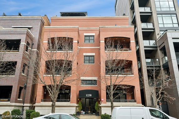 Front view of a multi-story brick building with balconies.