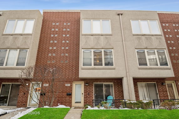 Front view of a multi-story brick townhouse.