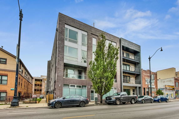 Front view of a multi-story apartment building with brick exterior.