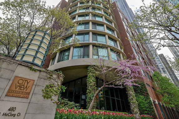 Front view of a modern multi-story condominium building with rounded design elements.