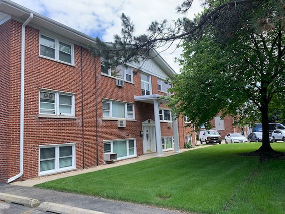 Front view of a brick three-story apartment building.