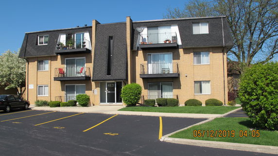 Front view of a multi-story apartment building with balconies.