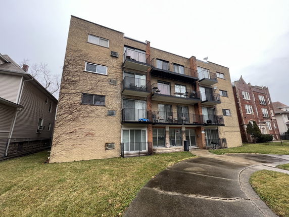 Front view of a multi-story apartment building with balconies.