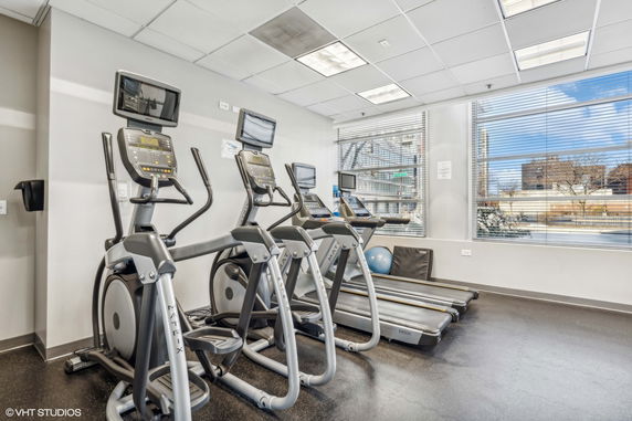 Indoor gym area with exercise equipment including treadmills and ellipticals.