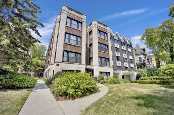 Front view of a multi-story apartment building with a brick facade.