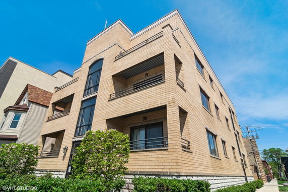 Front view of a multi-story brick building with large windows and balconies.