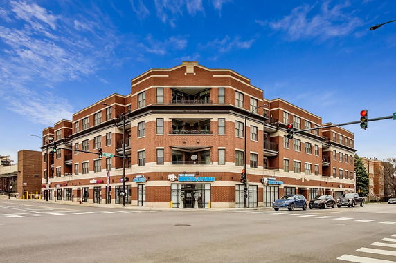 Front view of a multi-story brick building with commercial space on the ground floor.