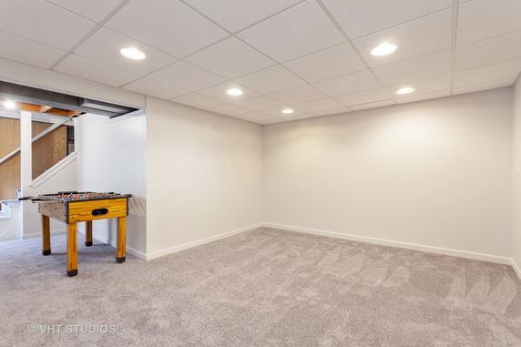 Indoor space with wall-to-wall carpeting and a foosball table.