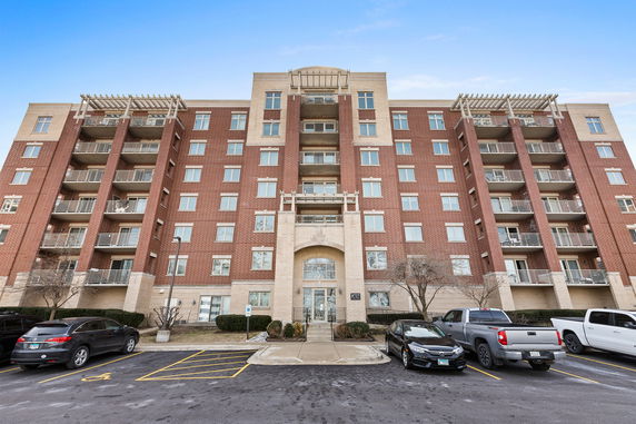 Front view of a multi-story apartment building with balconies.