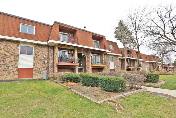Front view of a multi-story residential building with balconies.