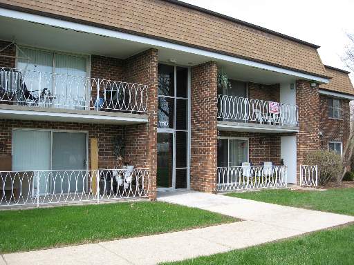 Front view of a two-story brick apartment building with balconies.