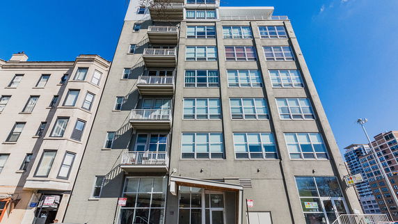 Front view of a multi-story apartment building with balconies.