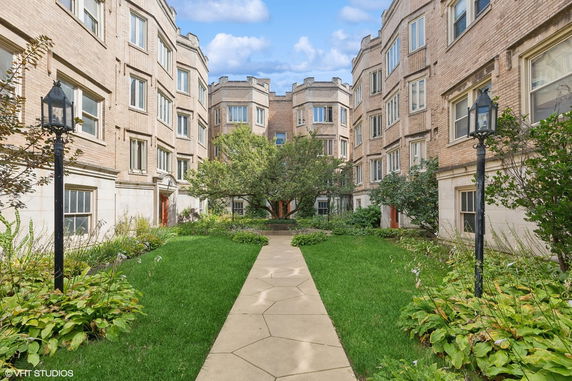 Front view of a multi-story brick building with a central courtyard.