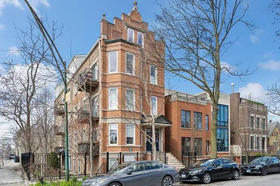 Front view of a multi-story brick building with large windows.