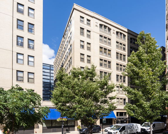 Front view of a multi-story building with a blue awning.