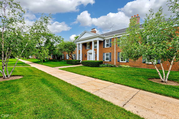 Front view of a two-story brick building with white columns and multiple windows.