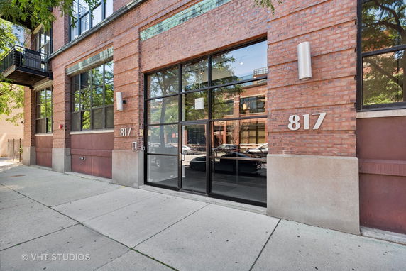 Front view of a brick building with large glass windows and the number 817 on its facade.