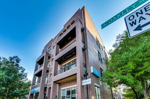 Front view of a multi-story brick building on a street corner.