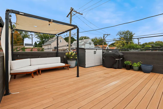 Rooftop area with seating, a canopy, and outdoor grill.