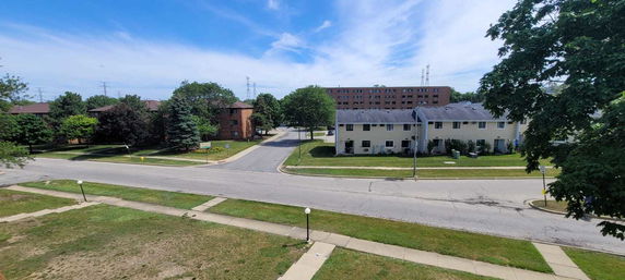 Wide view of residential buildings and street intersection from an elevated perspective.