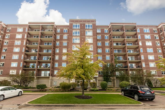 Front view of a multi-story apartment building with balconies.