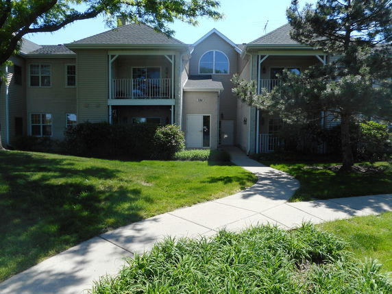 Front view of a two-story residential building with balconies and a central entrance.