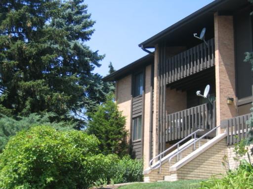 Front view of a multi-story apartment building with balconies and satellite dishes.