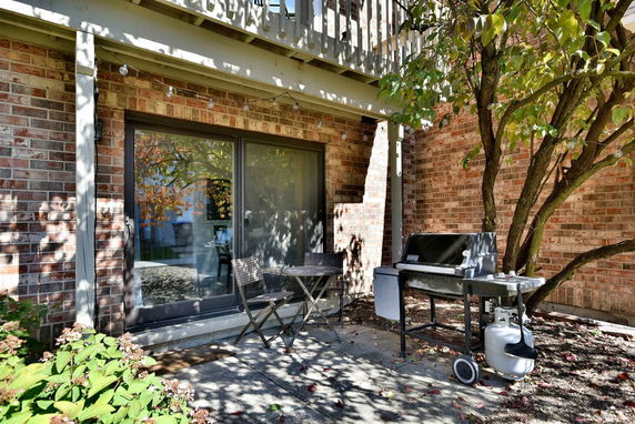 Front view of a house with a brick exterior and a small patio area.