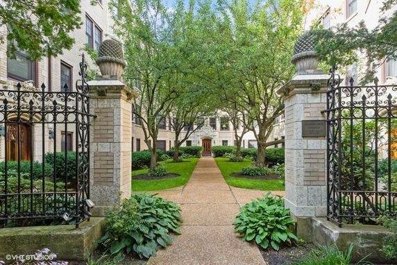 Front view of a building with a landscaped entrance and decorative gates.