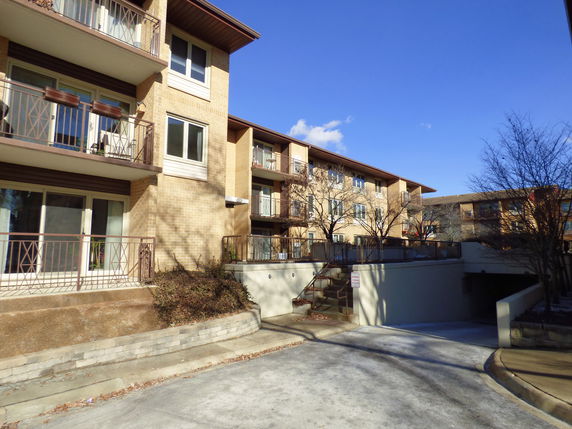 Front view of a multi-story apartment building with balconies.