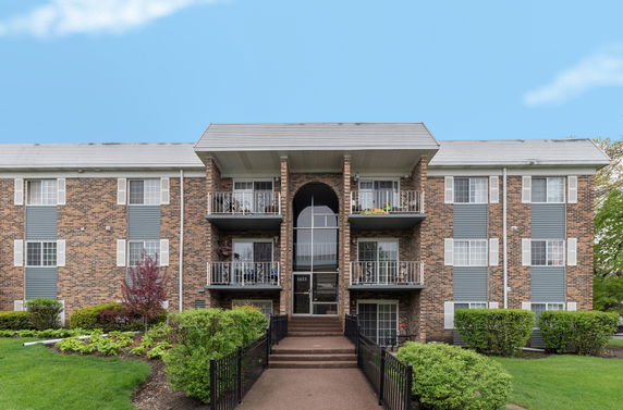 Front view of a three-story apartment building with balconies.