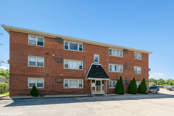 Front view of a three-story brick apartment building.