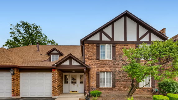Front view of a two-story house with a brick exterior and a double garage.