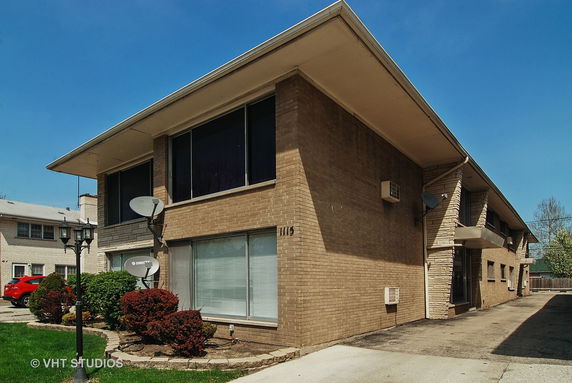 Front view of a two-story brick building with satellite dishes.