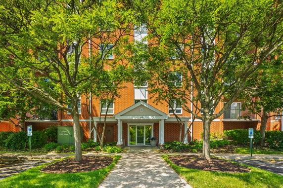 Front view of a multi-story building with a brick facade and entrance canopy.