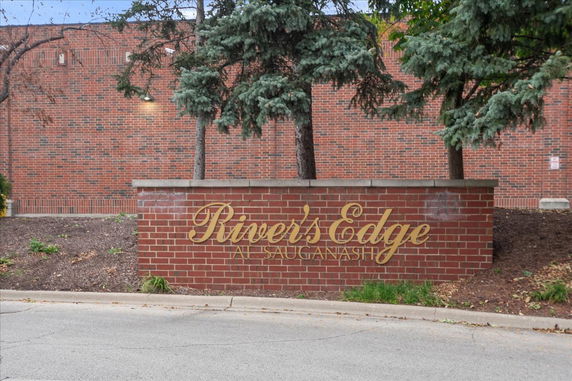Front view of a building with 'River's Edge' sign on a brick wall.